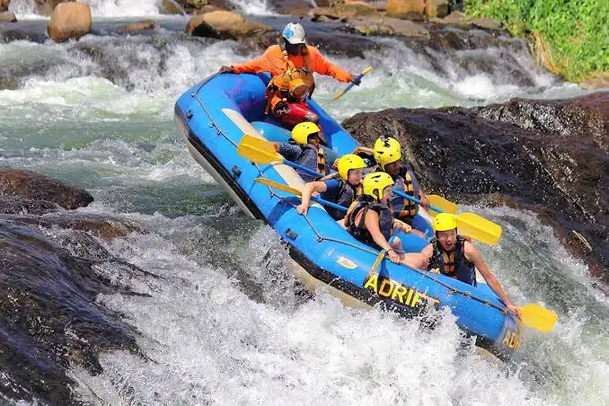 Rafting crew paddling through whitewater rapids on the Nile in Jinja